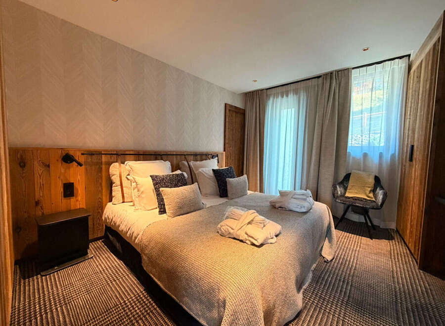 Experience ultimate comfort in this beautifully appointed bedroom, featuring a plush king-size bed adorned with soft linens and decorative pillows.