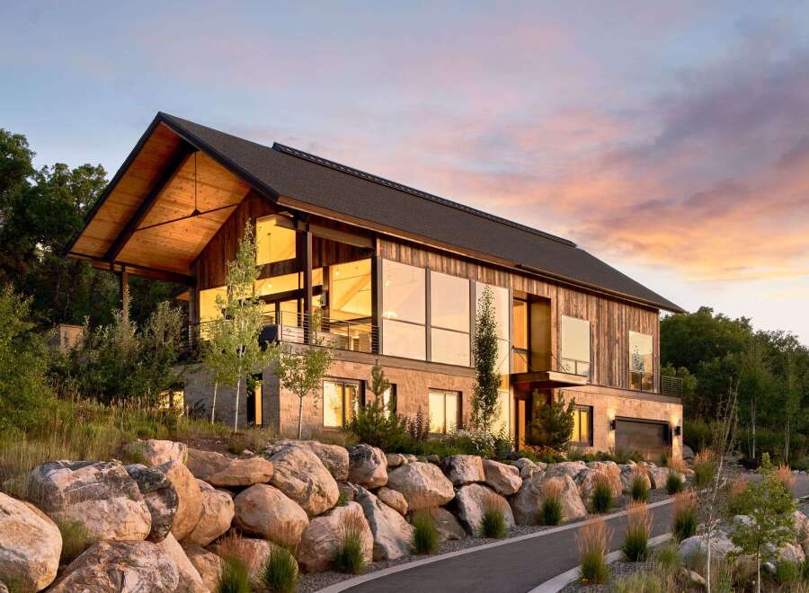 This stunning modern home boasts a striking architectural design with expansive windows that capture breathtaking views.