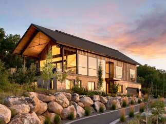 This stunning modern home boasts a striking architectural design with expansive windows that capture breathtaking views.