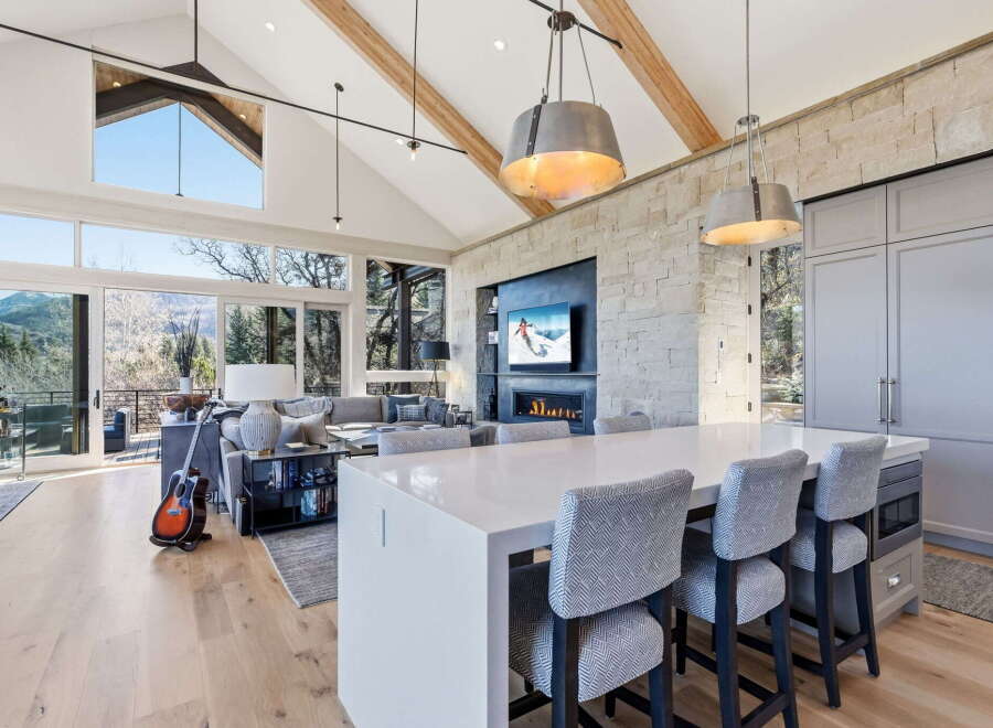 Experience luxury living in this stunning property featuring a modern kitchen with a large island and stylish seating.