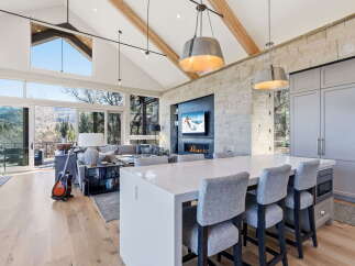Experience luxury living in this stunning property featuring a modern kitchen with a large island and stylish seating.