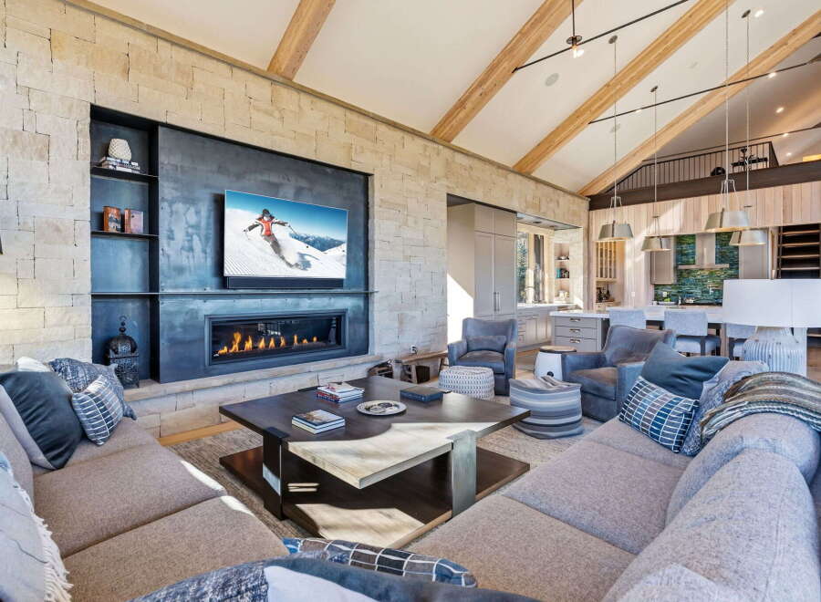 Experience luxury living in this stunning property featuring a cozy fireplace and a modern entertainment setup.