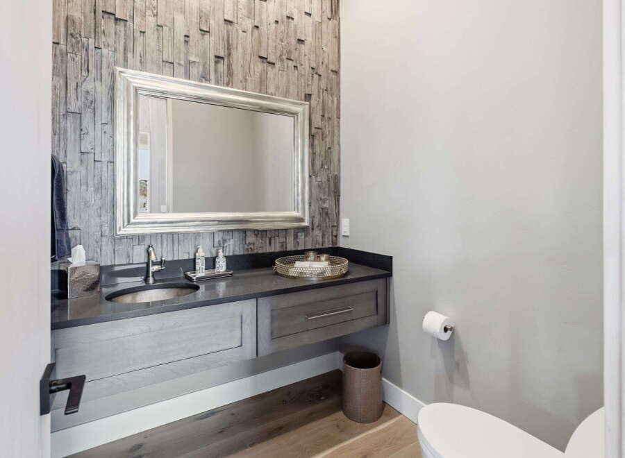 This stunning bathroom boasts a modern design with a floating vanity and a stylish wooden accent wall.