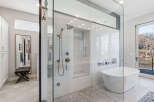 Step into luxury with this stunning bathroom featuring a spacious glass-enclosed shower and a modern soaking tub.
