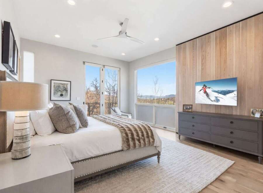 Experience luxury in this stunning bedroom featuring a cozy bed, a stylish dresser, and a modern TV.