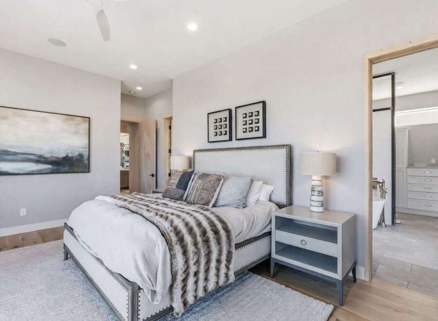 Step into luxury with this stunning bedroom, featuring a plush bed adorned with stylish pillows and a cozy throw.