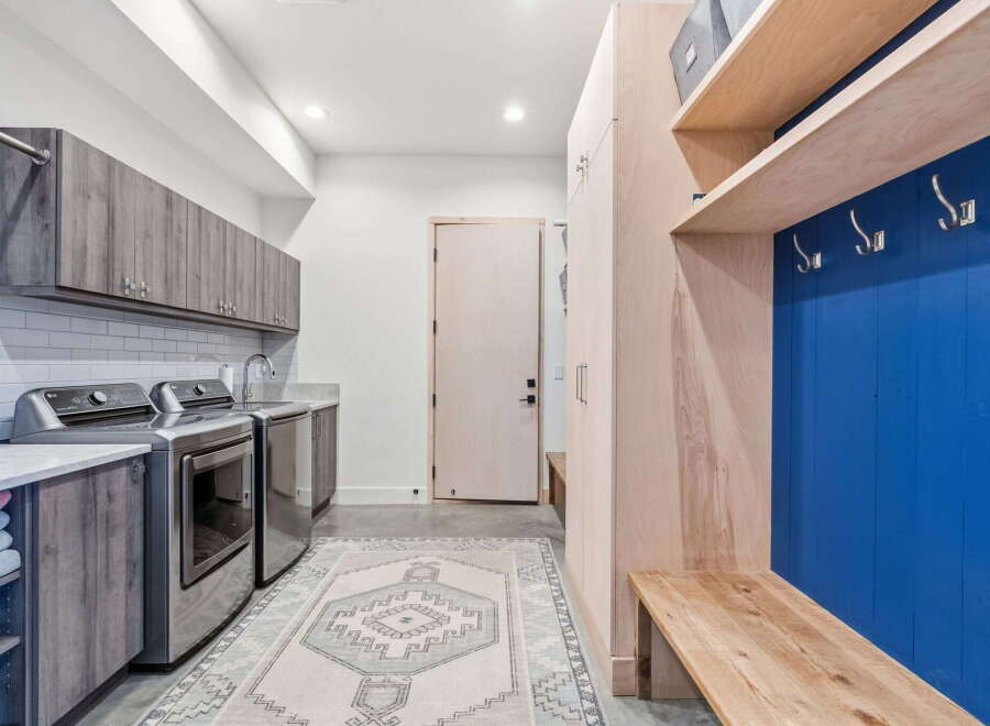 Step into this beautifully designed laundry room, featuring modern appliances and ample storage.