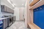 Step into this beautifully designed laundry room, featuring modern appliances and ample storage.