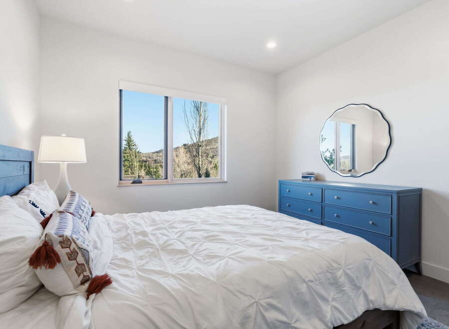 This stunning bedroom boasts a serene ambiance with its bright, airy design and beautiful mountain views.