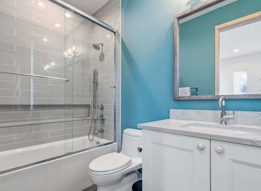 Step into a beautifully designed bathroom featuring a modern shower with glass doors and stylish gray tile.