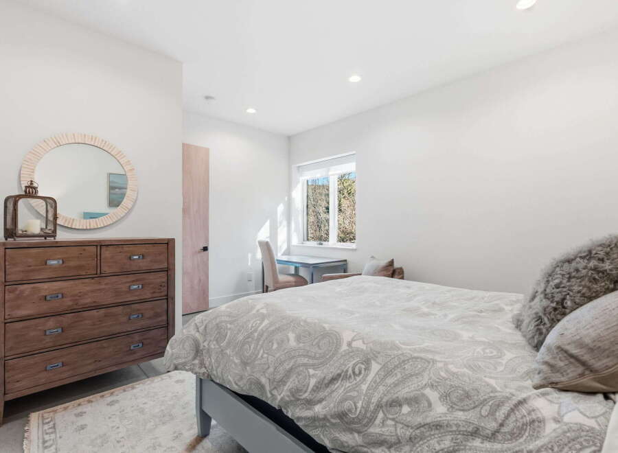 Step into this inviting bedroom, featuring a stylish dresser and a cozy bed.