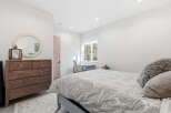 Step into this inviting bedroom, featuring a stylish dresser and a cozy bed.