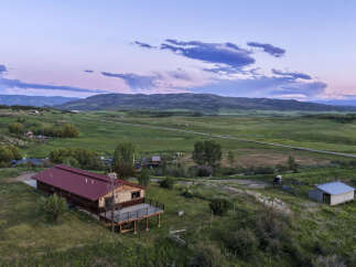 Experience serene mountain living with this stunning property featuring a charming log cabin and expansive acreage.
