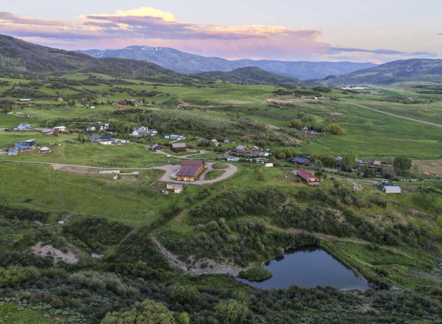 Discover this expansive rural property featuring a charming collection of homes nestled amidst rolling green hills and picturesque mountain vistas.