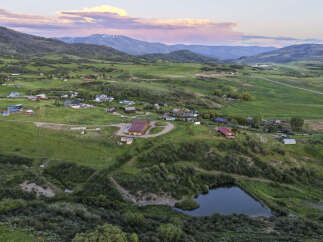 Discover this expansive rural property featuring a charming collection of homes nestled amidst rolling green hills and picturesque mountain vistas.