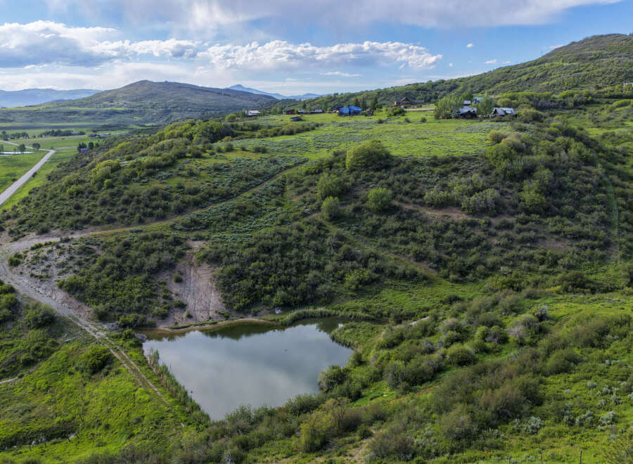 Discover this stunning property featuring a serene pond and rolling green hills, perfect for a private retreat.
