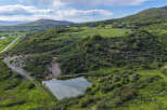 Discover this stunning property featuring a serene pond and rolling green hills, perfect for a private retreat.