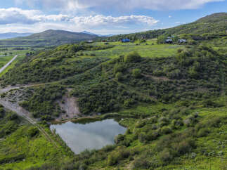 Discover this stunning property featuring a serene pond and rolling green hills, perfect for a private retreat.