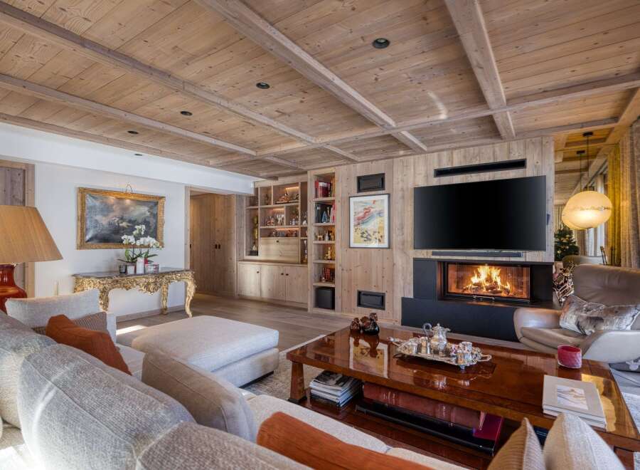 Experience luxury living in this stunning property, featuring a cozy fireplace and a sleek, modern TV.