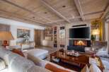 Experience luxury living in this stunning property, featuring a cozy fireplace and a sleek, modern TV.