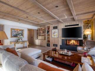 Experience luxury living in this stunning property, featuring a cozy fireplace and a sleek, modern TV.