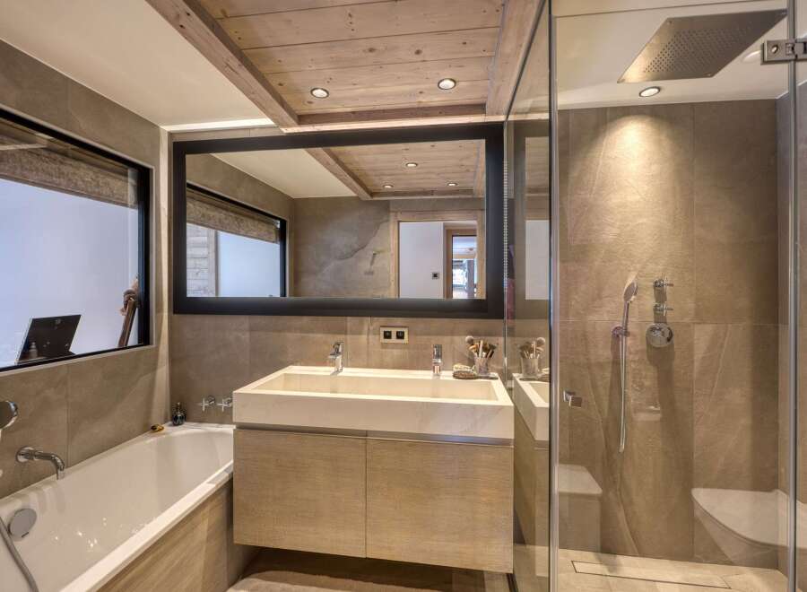 This luxurious bathroom features a modern design with a spacious walk-in shower and a sleek double vanity.