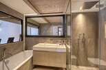 This luxurious bathroom features a modern design with a spacious walk-in shower and a sleek double vanity.