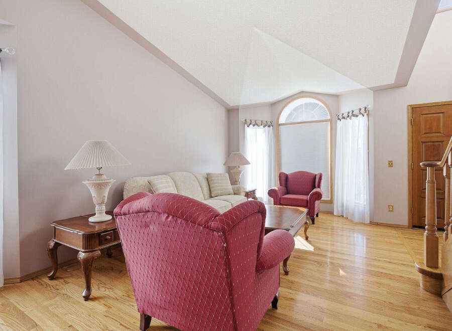 This stunning living room boasts a vaulted ceiling and elegant hardwood floors, creating a spacious and inviting atmosphere.
