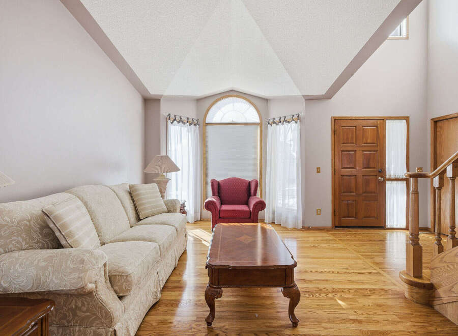 Step into luxury with this stunning living room, featuring a cozy sofa and a stylish red armchair.