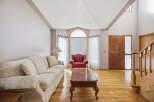 Step into luxury with this stunning living room, featuring a cozy sofa and a stylish red armchair.