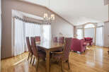 This elegant dining room boasts a beautiful wooden table and chairs, perfect for hosting dinner parties.
