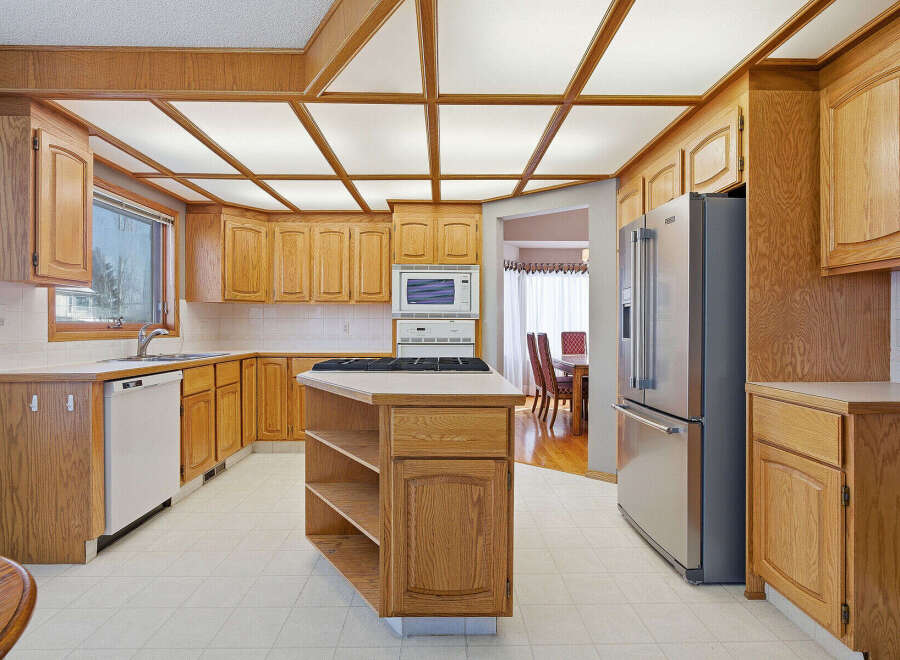 This stunning kitchen boasts beautiful wooden cabinetry and a unique ceiling design, creating a warm and inviting atmosphere.