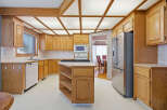 This stunning kitchen boasts beautiful wooden cabinetry and a unique ceiling design, creating a warm and inviting atmosphere.