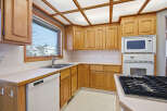 This charming kitchen boasts beautiful wooden cabinetry and a bright, inviting atmosphere.