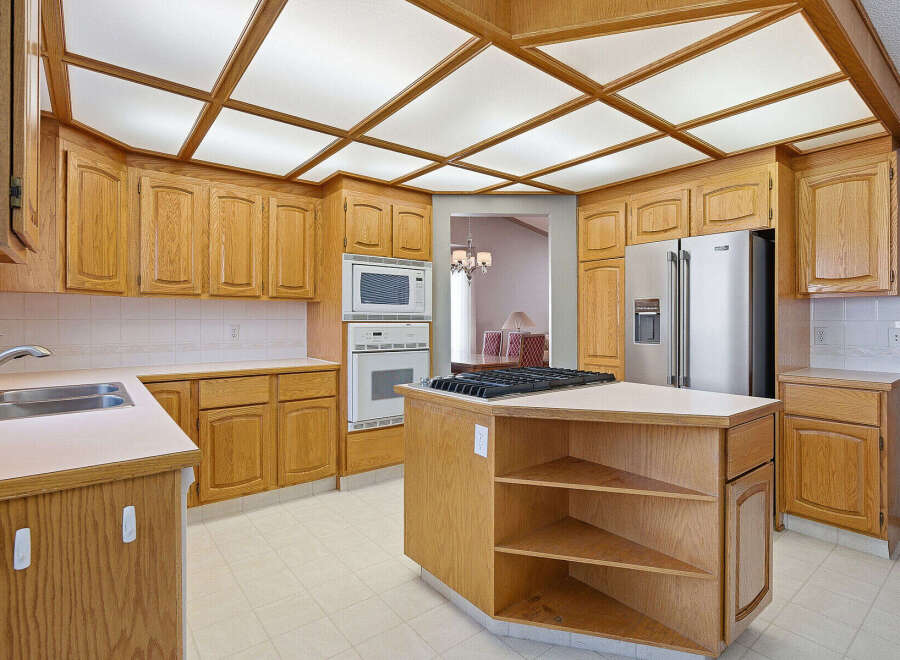 This stunning kitchen boasts beautiful wooden cabinetry and a modern stainless steel refrigerator.