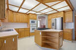 This stunning kitchen boasts beautiful wooden cabinetry and a modern stainless steel refrigerator.
