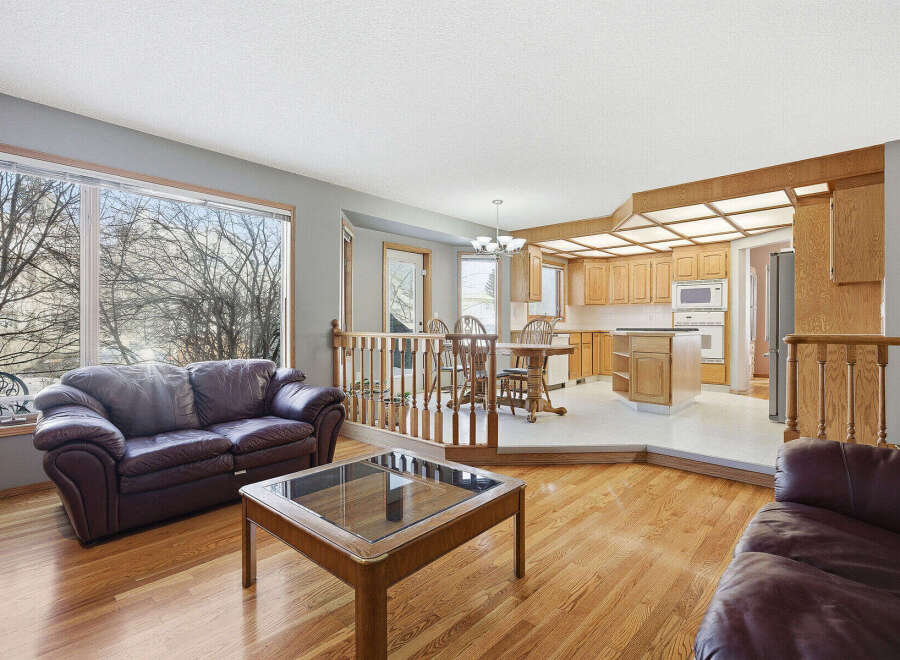 This stunning property boasts a spacious living area with hardwood floors and a cozy leather sofa, perfect for relaxing.
