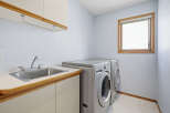 This laundry room offers a functional and organized space for all your washing needs.