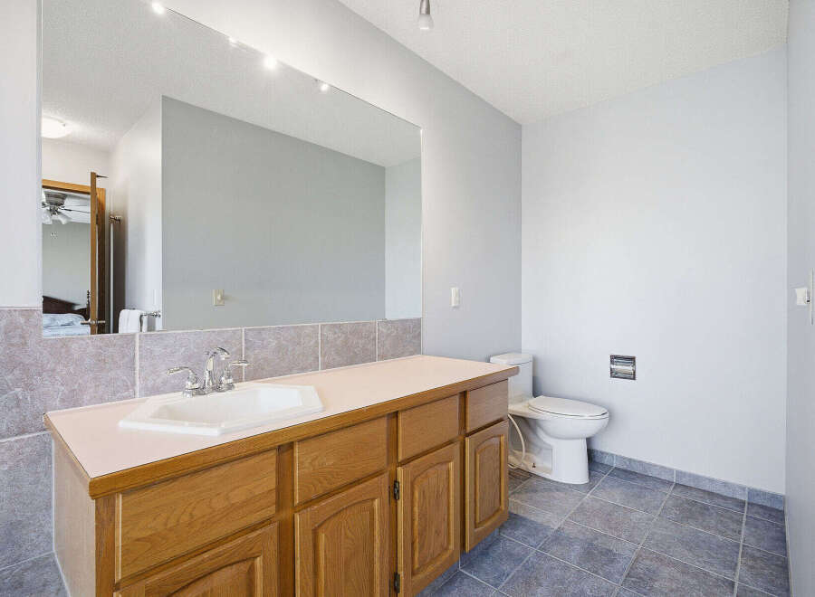This spacious bathroom features a large vanity with ample storage, perfect for keeping your essentials organized.