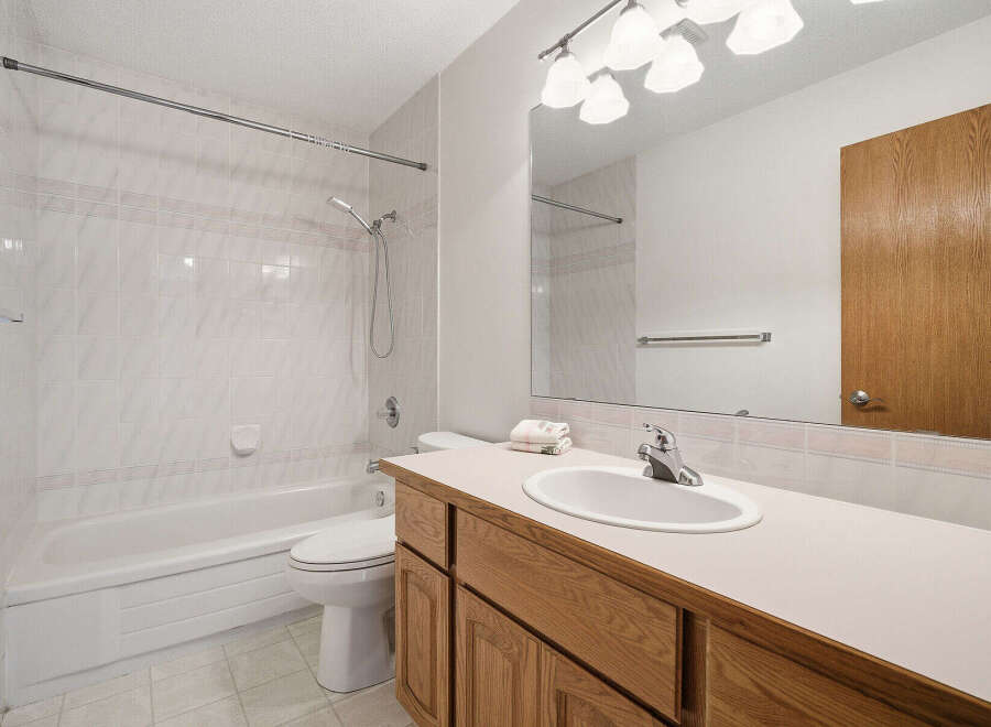 This bathroom features a clean and bright design with white tile and a neutral color palette.
