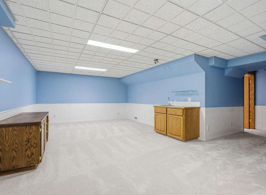 Discover the potential of this spacious property! This room features a clean, neutral color palette with a combination of blue and white walls, creating a bright and inviting atmosphere.