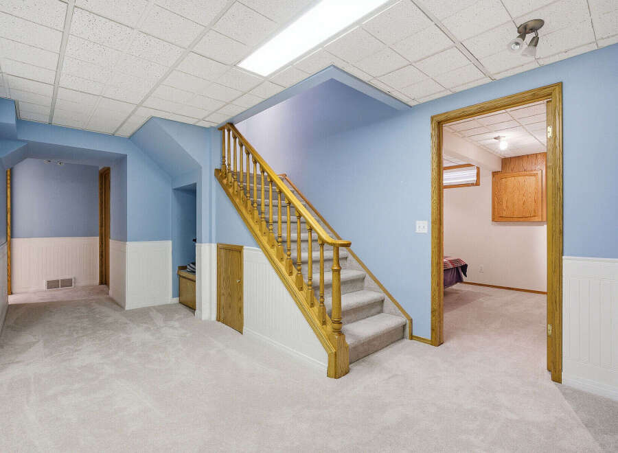 This inviting property boasts a spacious interior with a well-lit staircase, perfect for comfortable living.