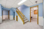 This inviting property boasts a spacious interior with a well-lit staircase, perfect for comfortable living.