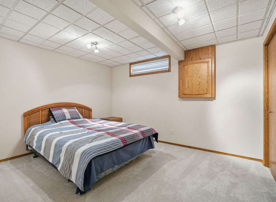 This cozy bedroom features a comfortable bed with a stylish headboard and a mix of patterned bedding.