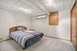 This cozy bedroom features a comfortable bed with a stylish headboard and a mix of patterned bedding.