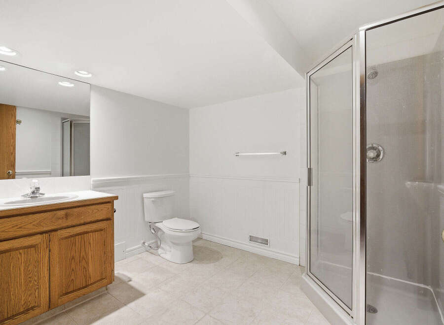 This spacious bathroom features a modern design with a walk-in shower and a sleek vanity.