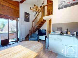 Discover this charming property featuring a cozy living space with a wooden staircase and a modern kitchen.