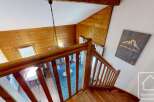 Discover the charm of this stunning property, featuring a beautifully crafted wooden staircase and a cozy interior.