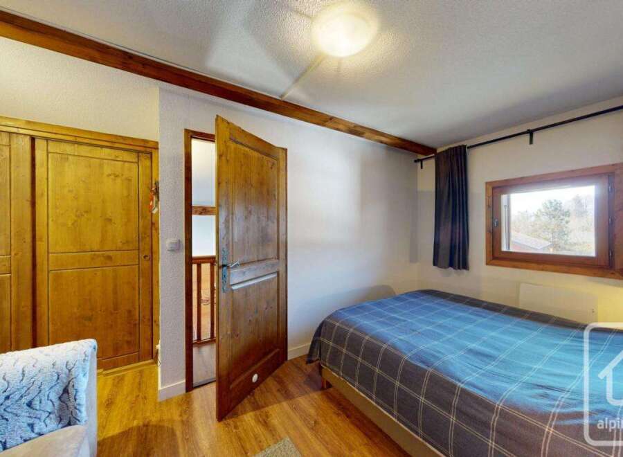 Discover this charming property featuring a cozy bedroom with a comfortable bed and a wooden wardrobe.