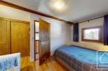 Discover this charming property featuring a cozy bedroom with a comfortable bed and a wooden wardrobe.